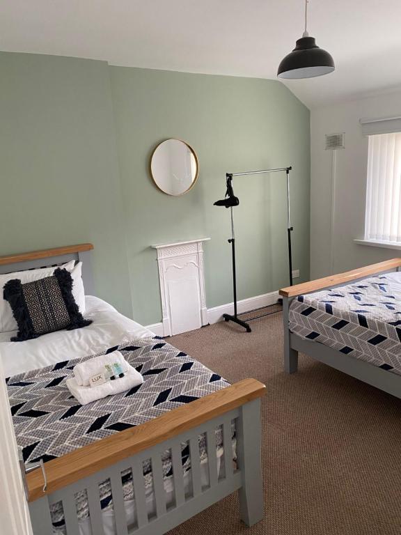 a bedroom with a bed and a mirror on the wall at Springfield Retreat in Risca