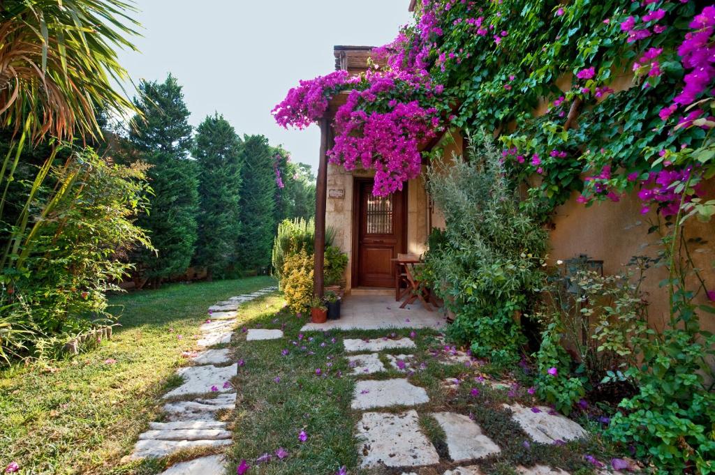 a garden with purple flowers on a building at Kalimera Archanes Village in Archanes