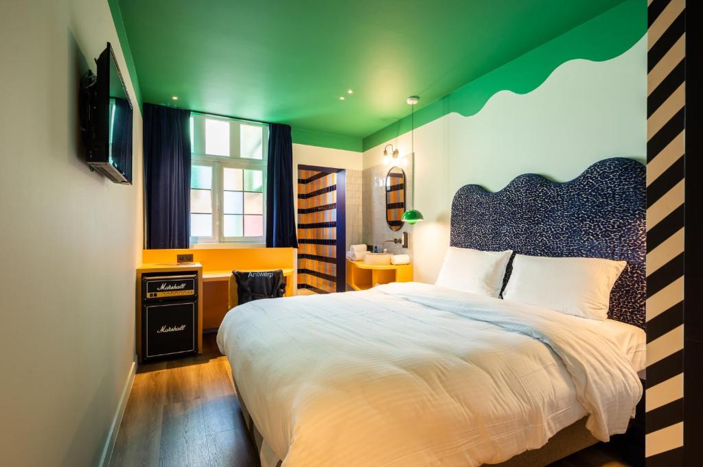 ein Schlafzimmer mit einem großen Bett mit grüner Decke in der Unterkunft P6 Antwerp in Antwerpen