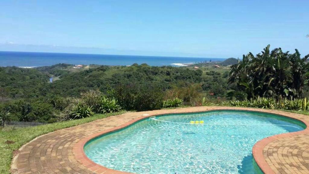 a swimming pool with the ocean in the background at Ku-Boboyi River Lodge in Port Edward
