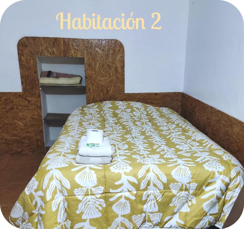 Una cama con una manta amarilla y blanca. en Munay San Blas Wasi, en Cusco