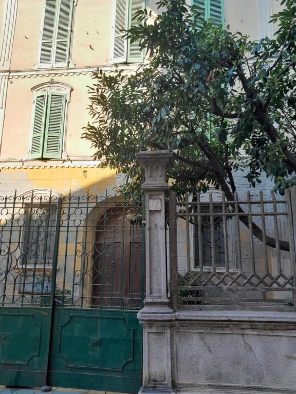 a building with a gate and a tree in front of it at Ventisette in Cremona