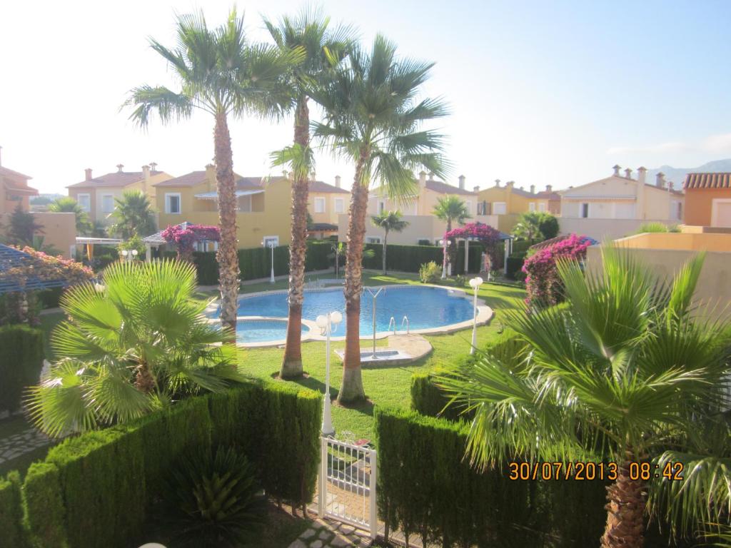 オリーバにあるFamily Beach Malibú IIのヤシの木と家々が茂るプールの景色を望めます。