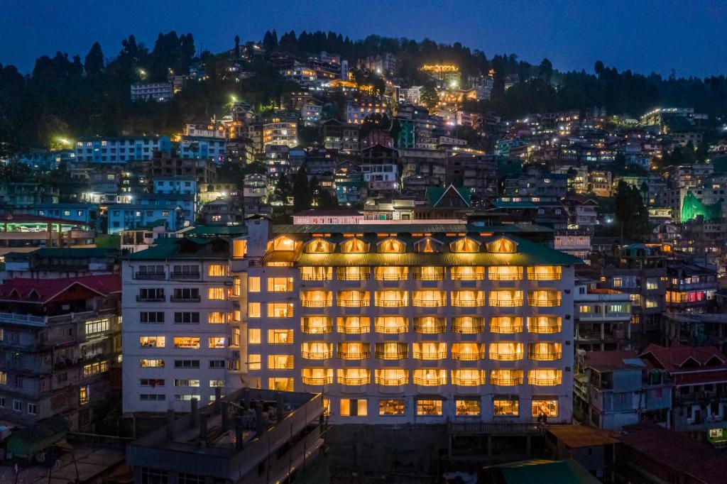 ein beleuchtetes Gebäude in einer Stadt in der Nacht in der Unterkunft Udaan Himalayan Suites and Spa in Darjeeling