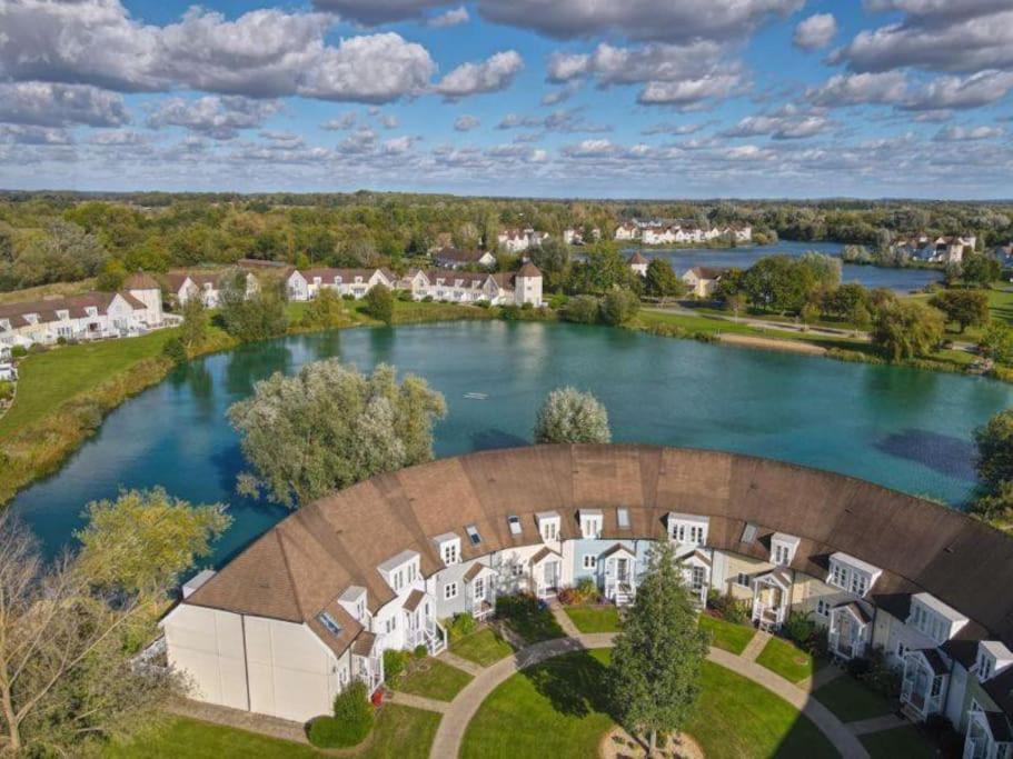 an aerial view of an estate with a lake at Charming Lake House nature retreat in Cotswold Water Park, South Cerney near Cirencester in Cirencester