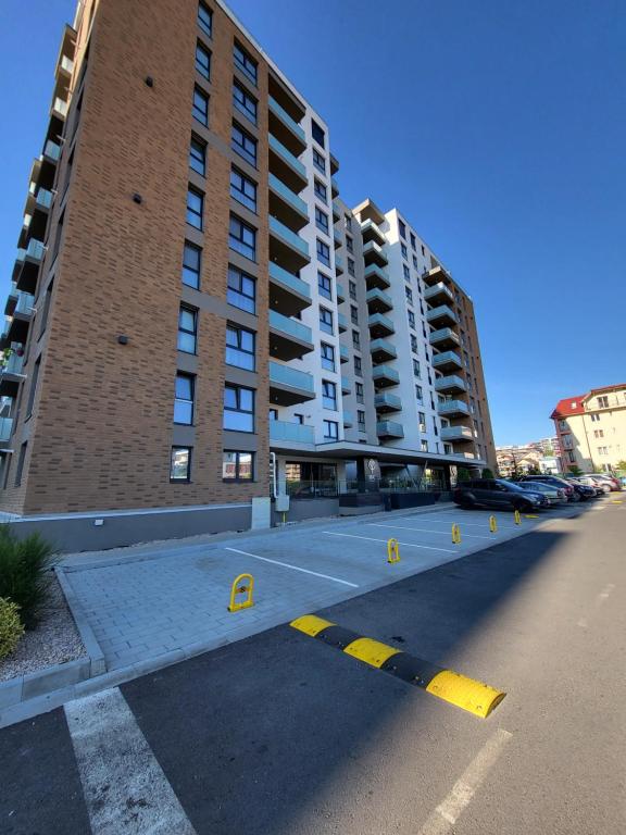 un parking vide en face d'un grand bâtiment dans l'établissement Dacrilo Apartments Cluj-Napoca 11, à Cluj-Napoca