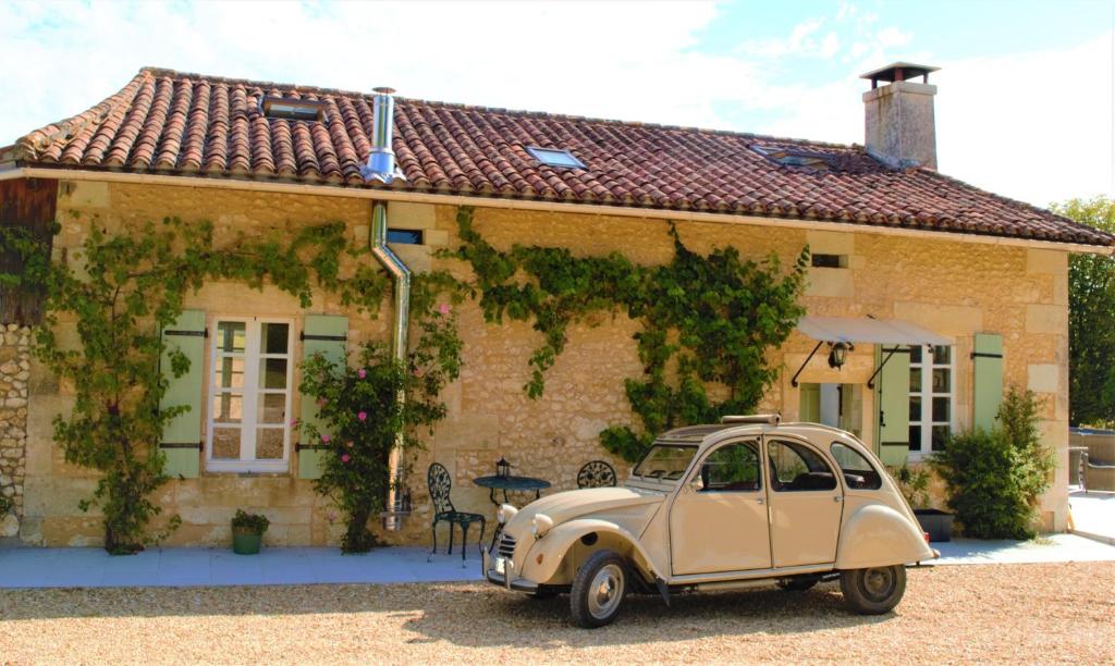 an old car parked in front of a house at Le Shedeaux in Saint-Privat-des-Prés