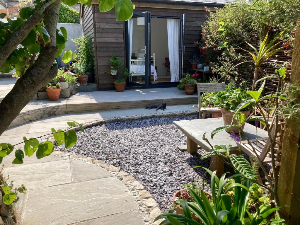 a garden with a bench and some plants at The Little Studio in Penzance