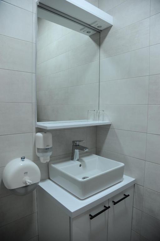 a white bathroom with a sink and a mirror at Prenociste kod Brana in Čačak