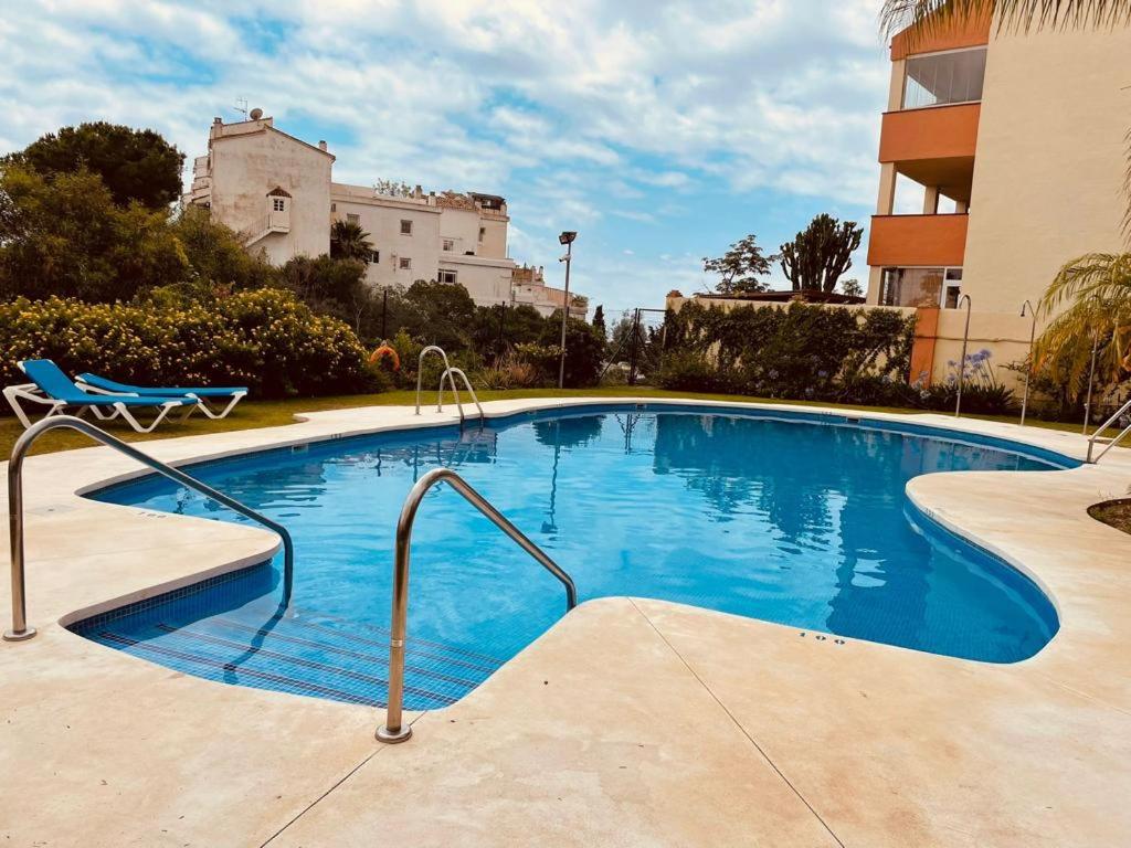 a large swimming pool with a chair and a building at Appartement Paraiso Riviera del Sol-Mijas in Málaga