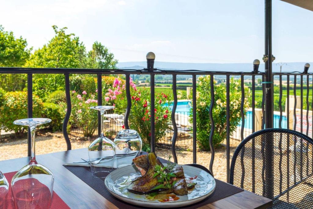 uma mesa com um prato de comida e copos de vinho em Vilajoun em Joucas