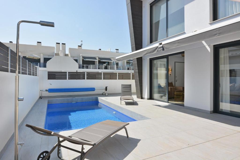 uma piscina ao lado de uma casa em Luxury Villa by NRAS em Gran Alacant