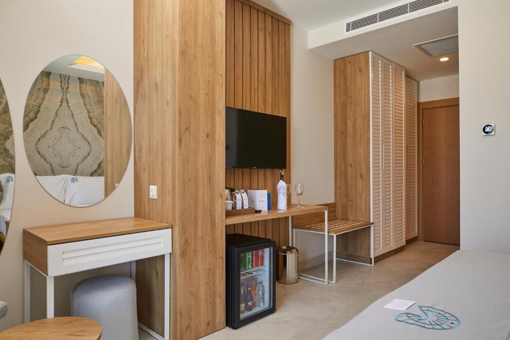 a room with a bed and a desk and a mirror at Rammos Managed By Dedeman in Bodrum City
