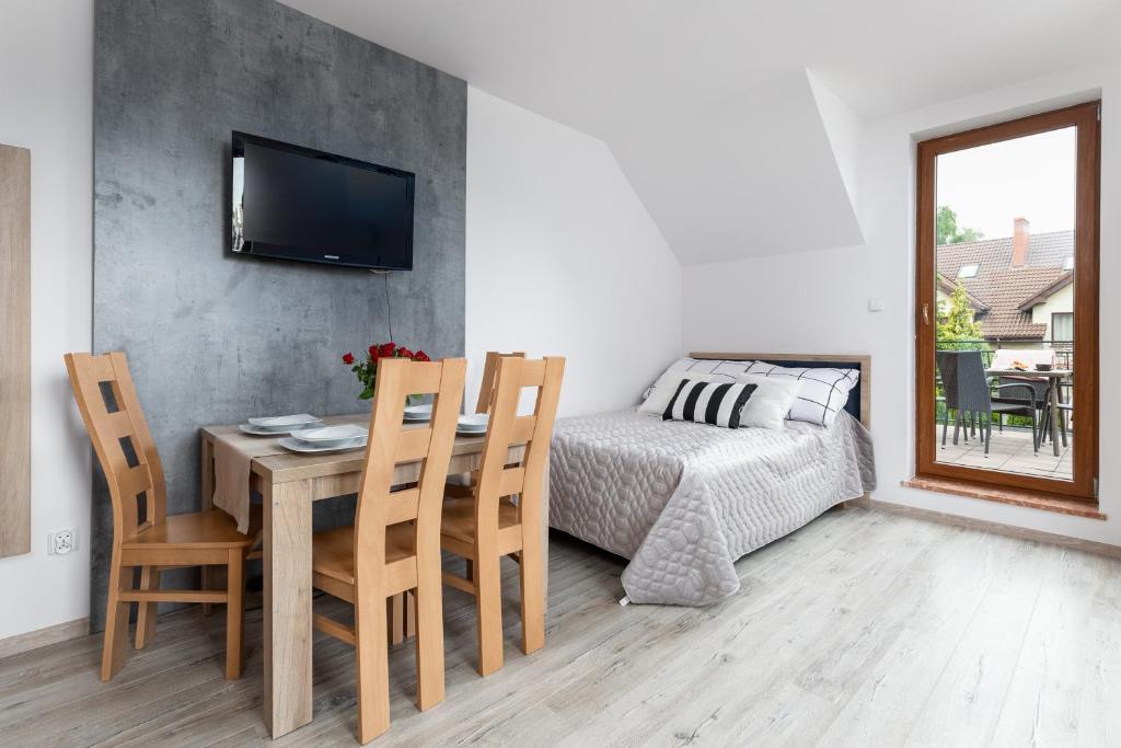 a dining room with a table and chairs and a bed at Na mieczowej 2f in Świnoujście