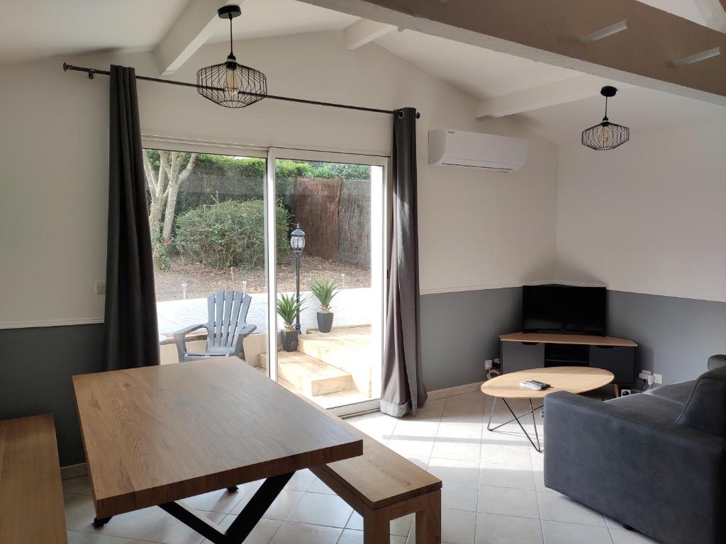 ein Wohnzimmer mit einem Sofa und einem Tisch in der Unterkunft Charmante maisonnette à 2 min du Centre Ville in Casteljaloux
