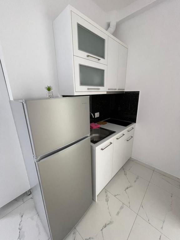 a white kitchen with a refrigerator and a microwave at Villa Denis Ksamil in Ksamil