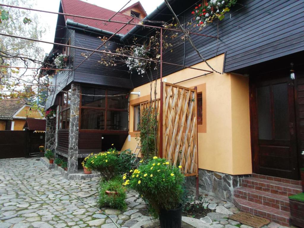 una casa con una puerta de madera y algunas flores en Pensiunea Sandra, en Sibiel