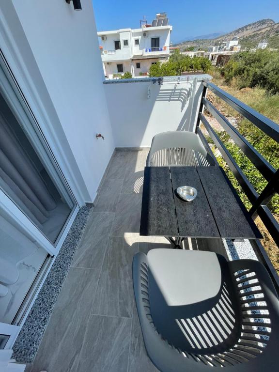 a balcony with a wooden table and chairs at Villa Denis Ksamil in Ksamil
