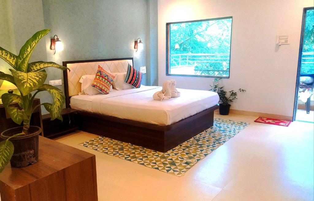 a bedroom with a bed with a stuffed animal on it at Hiranya Resorts in Daulatābād