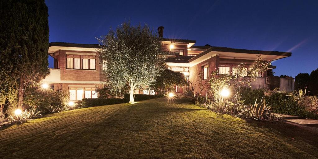 una grande casa con luci nel cortile di notte di La Dimora Del Bassotto a San Giuliano Terme