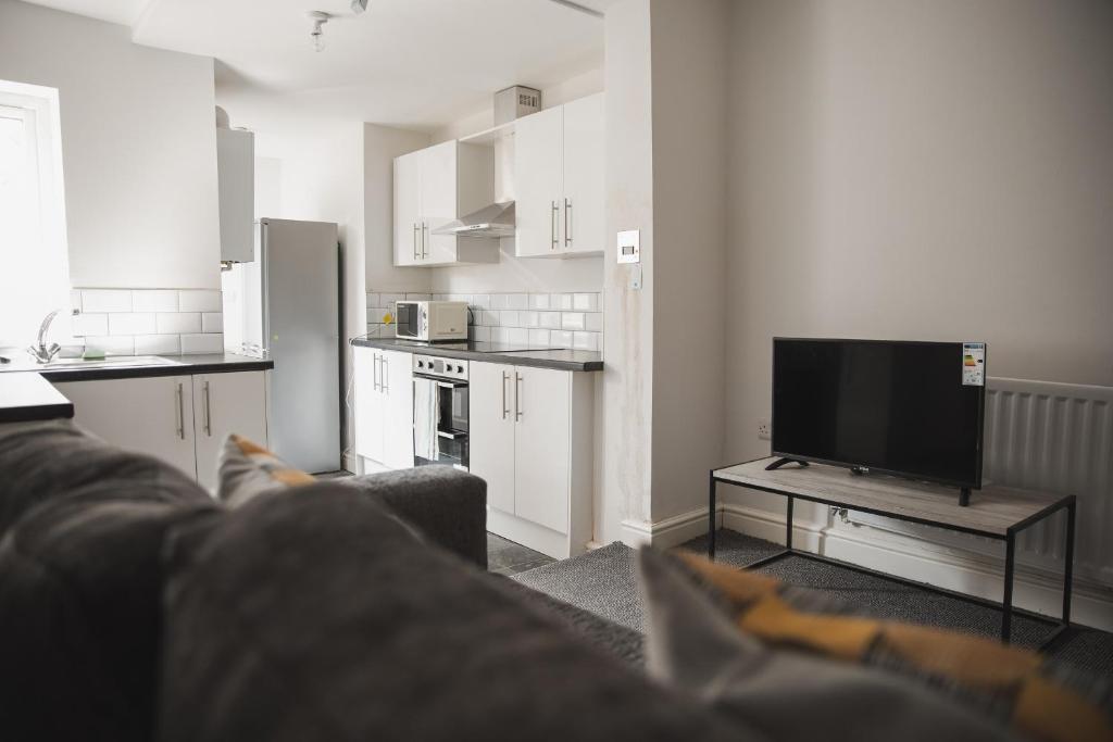 a living room with a couch and a flat screen tv at Green Park house in Leicester