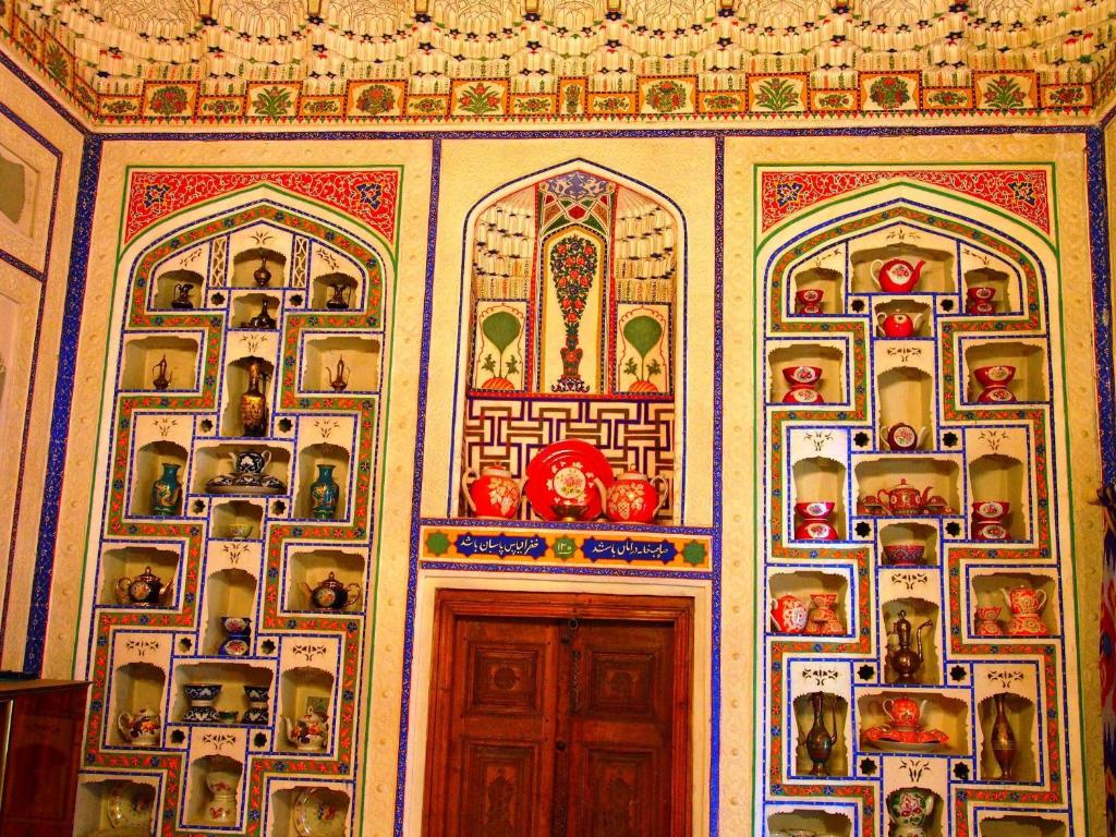 una habitación con una puerta con pinturas en la pared en Arabon Hotel, en Bukhara