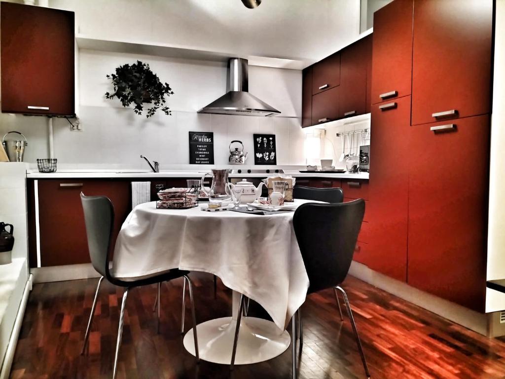 a kitchen with a table with chairs and red cabinets at Residenza Santi Muratori in Ravenna