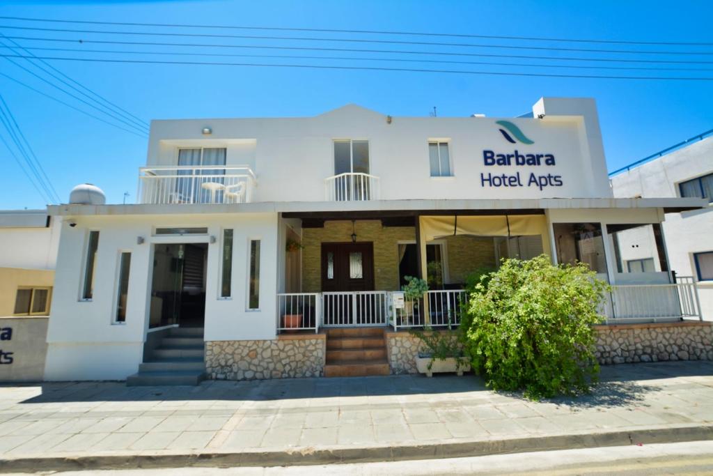 a white building with a sign that reads benaria hotel aids at Barbara Hotel Apts in Ayia Napa