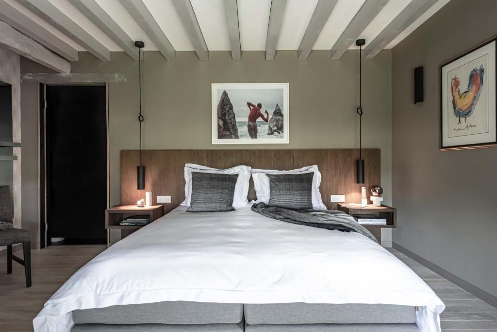 a bedroom with a large white bed with two tables at MAISON de la Bonne Vie in Thérondels