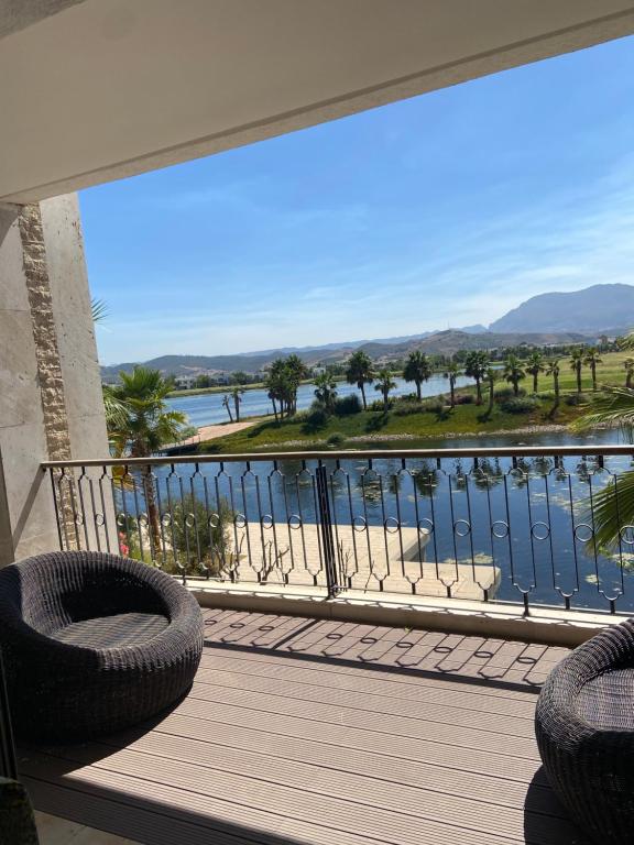 d'un balcon avec des chaises et une vue sur l'eau. dans l'établissement Luxueux appartement Ritz Carlton Marina Smir, à Sania Torres