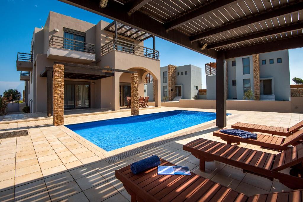 a villa with a swimming pool and a house at Blue Wave Villa - road view in Gennadi