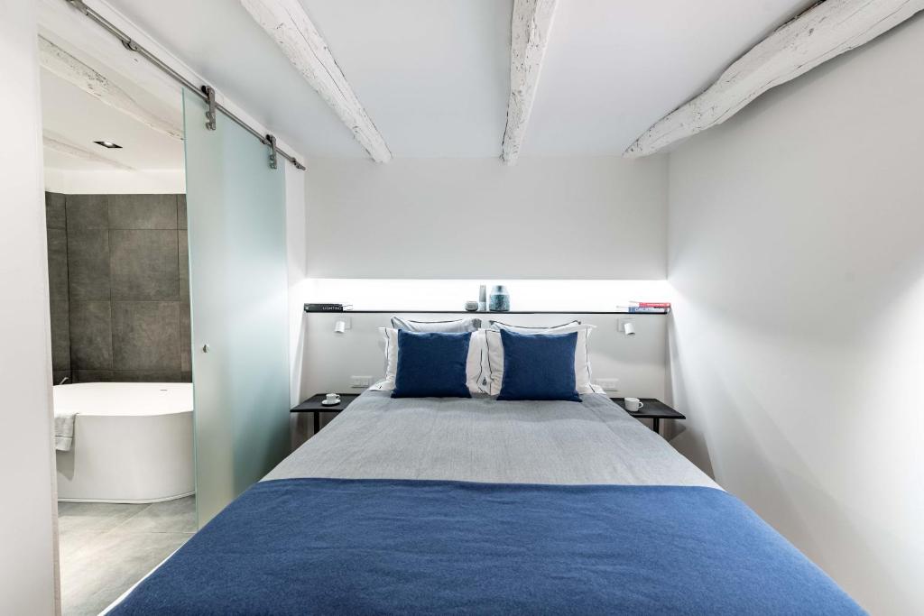 a bedroom with a blue bed and a bath tub at MAISON de la Bonne Vie in Thérondels