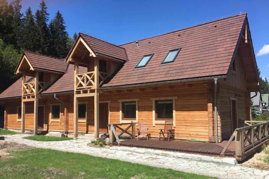 a large log cabin with a large deck at Chata Przystanek Izery in Szklarska Poręba