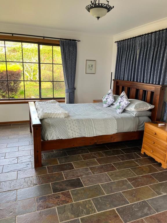 a bedroom with a bed and a large window at Bicheno getaway for two in Bicheno
