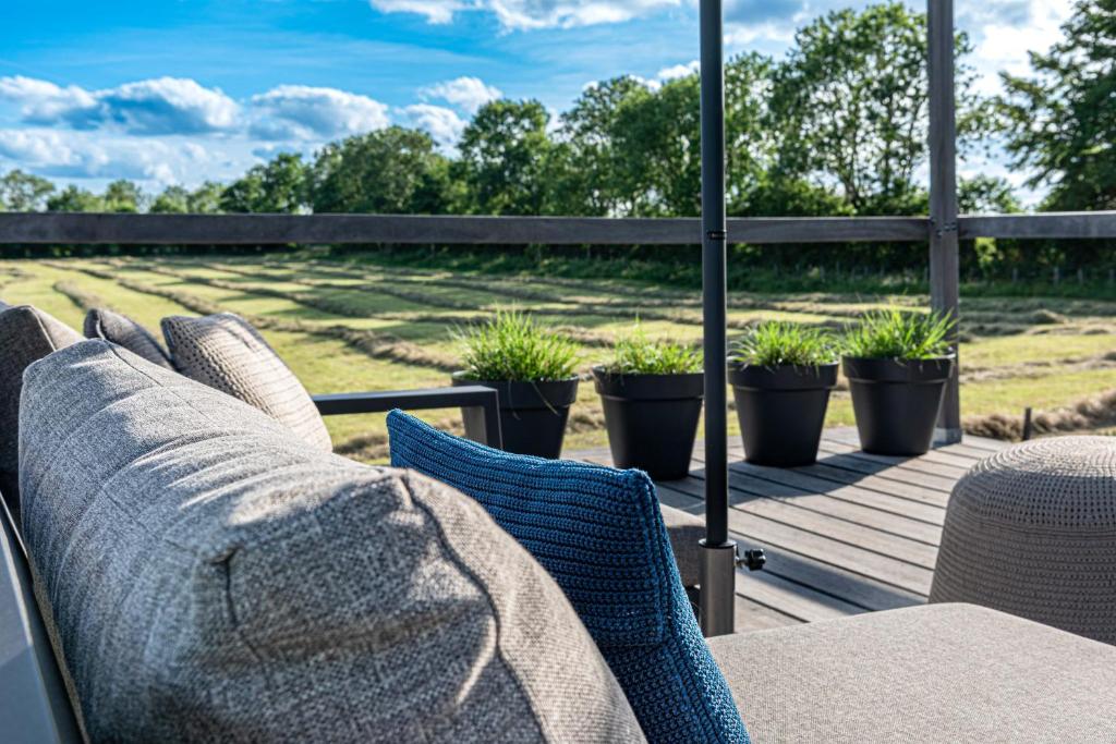 a patio with a couch and chairs on a deck at MAISON de la Bonne Vie in Thérondels