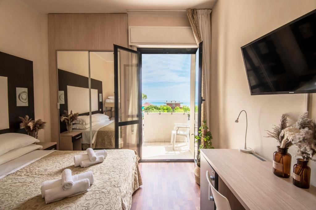 una camera con letto e vista su un balcone di Hotel Baby B&B a Milano Marittima