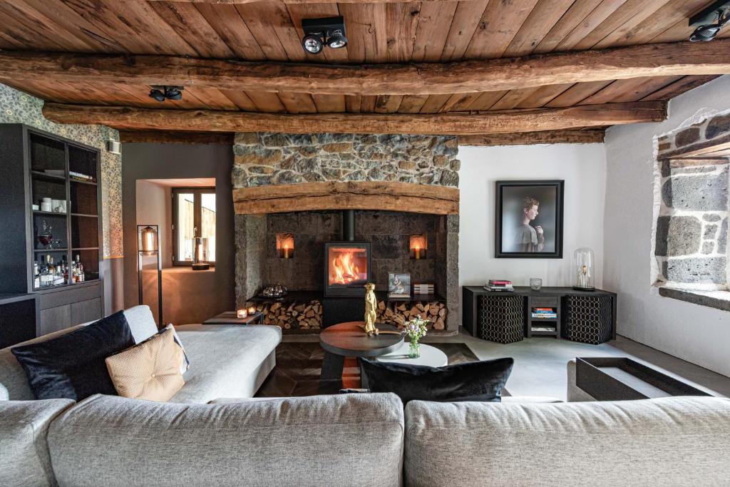 a living room with a couch and a fireplace at MAISON de la Bonne Vie in Thérondels