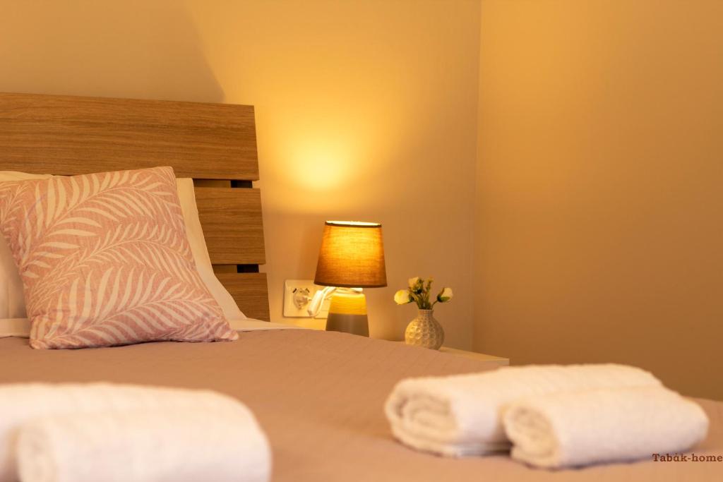 een slaapkamer met een bed met twee handdoeken erop bij Tabak home Sea side apartment in Chania