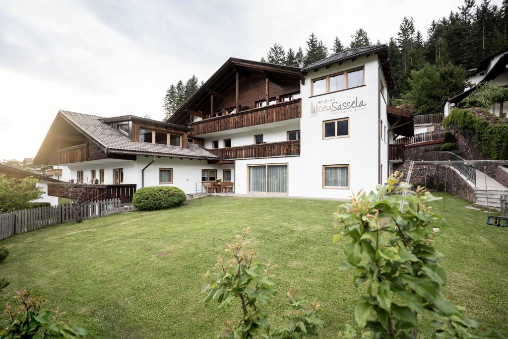 een huis met een grote tuin ervoor bij Residence Cesa Sassela in Ortisei