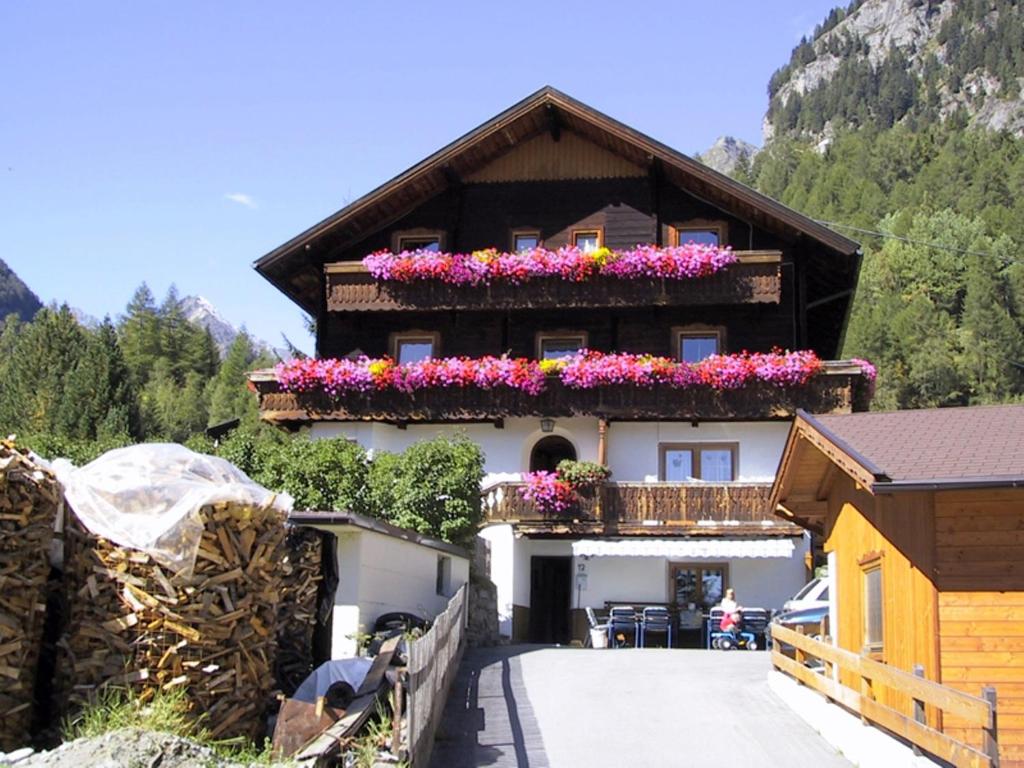 una casa con flores en sus balcones en Gästehaus Conny, en Prägraten am Großvenediger