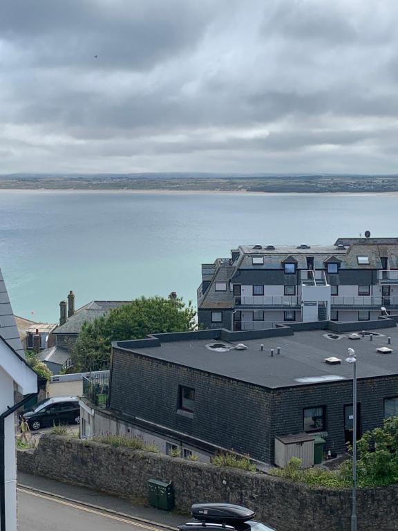 een uitzicht op een grote hoeveelheid water met gebouwen bij Shoreline in St Ives