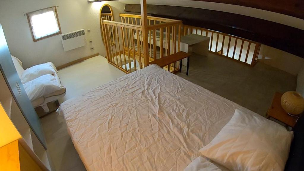 a bedroom with a large white bed in a room at Les margouillats - maisonnette à 2 pas de la plage in Vias