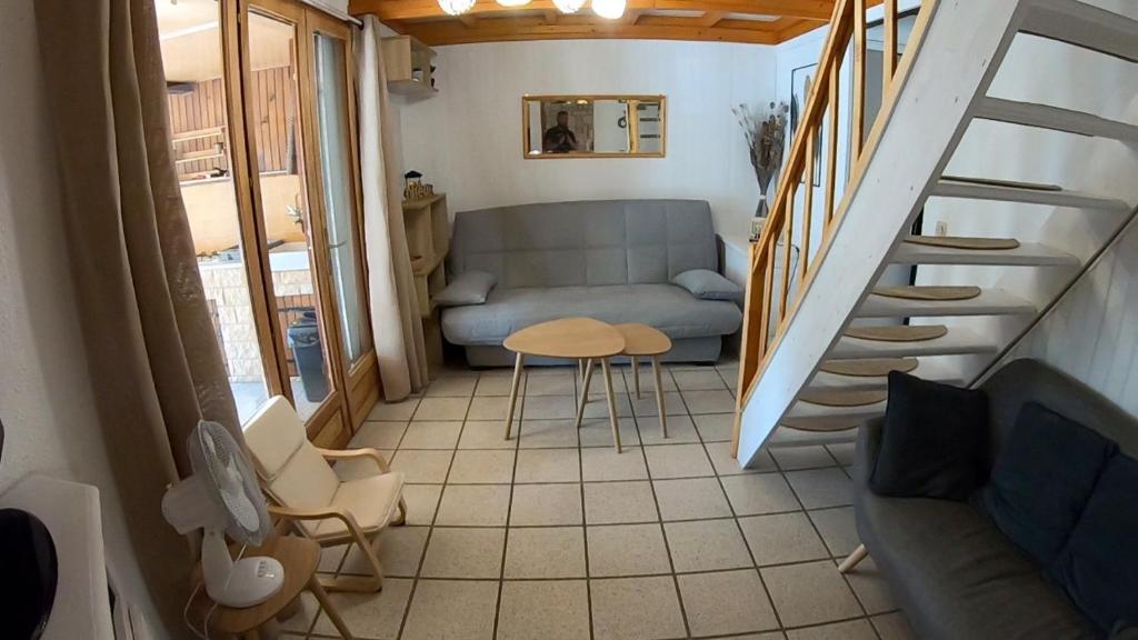 a small living room with a couch and a table at Les margouillats - maisonnette à 2 pas de la plage in Vias