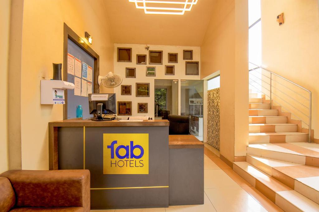 a lobby of a hotel with a counter and stairs at FabExpress Glory in Chinchwad
