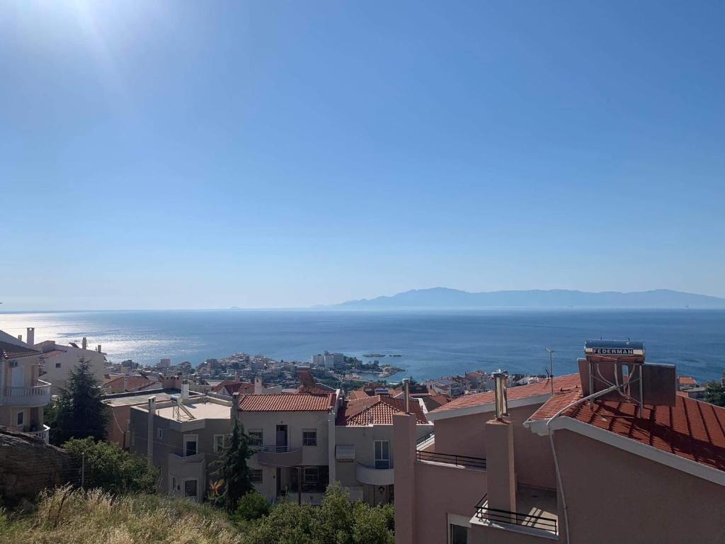 a city with buildings and the ocean in the background at Breathtaking sea view in Kavala