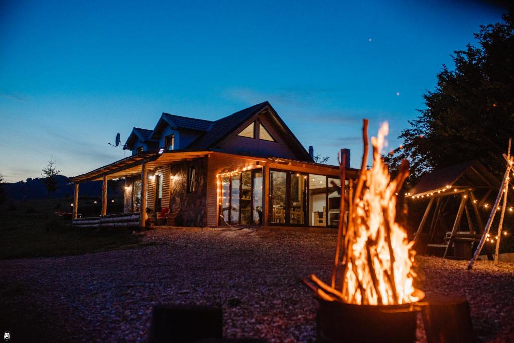 eine Feuerstelle vor einem Haus in der Nacht in der Unterkunft La Cabană in Vişeu de Jos