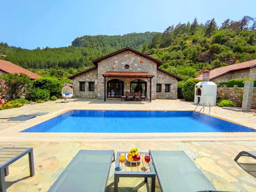 a large swimming pool in front of a house at Villa Kayakoy 3 in Fethiye