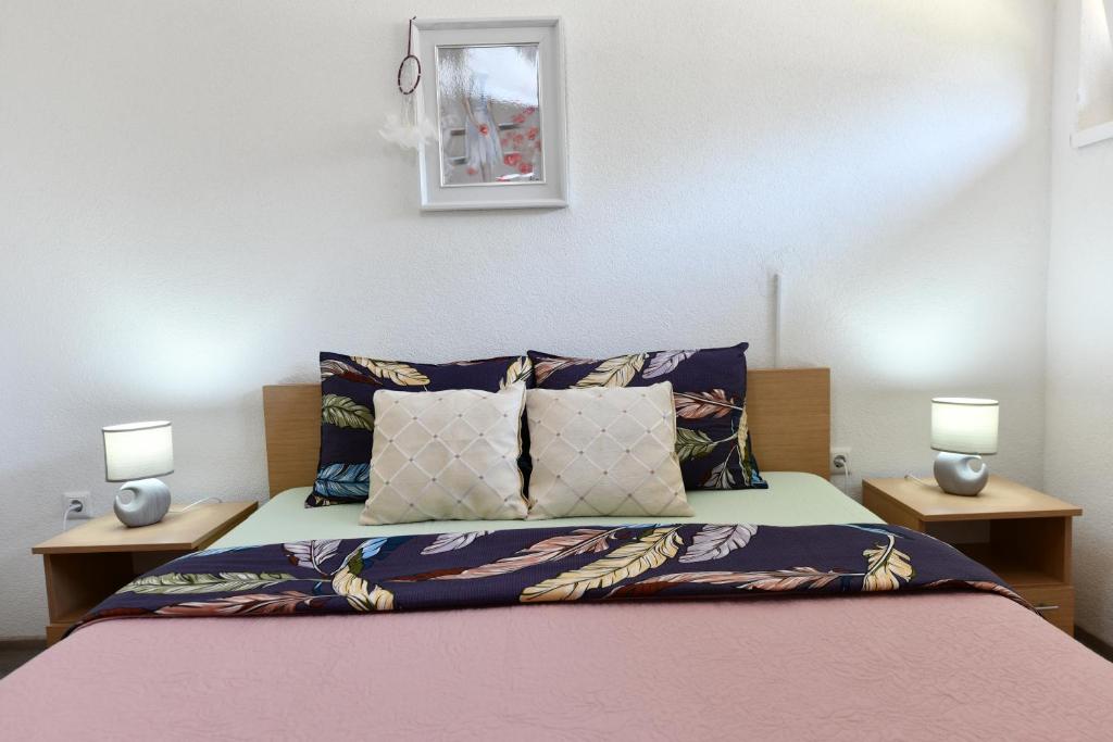 een slaapkamer met een bed met 2 nachtkastjes bij Apartman Petra in Plitvička Jezera
