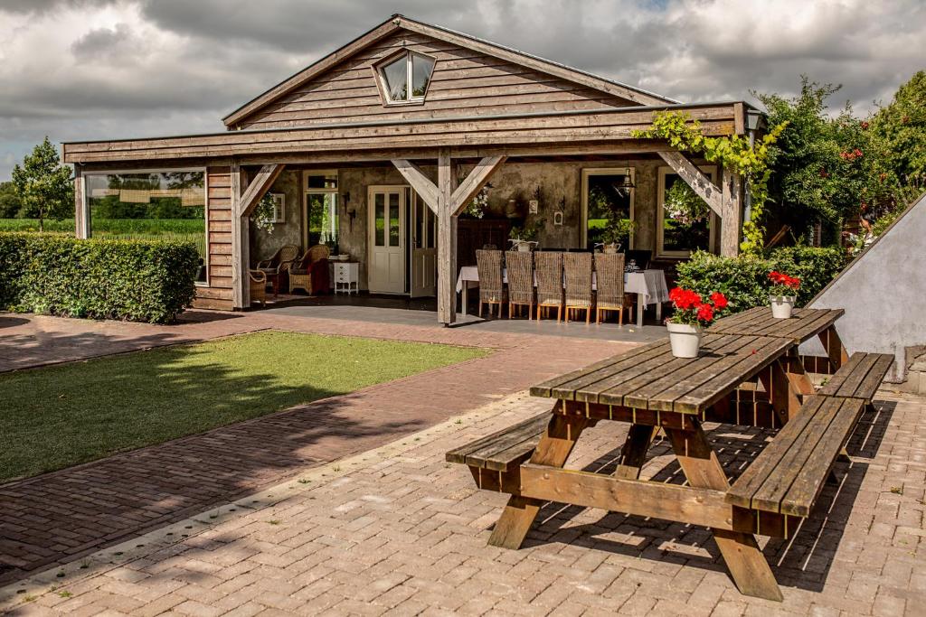 un patio con una mesa de picnic y una casa en Gasthoeve-De-Drie-Eiken en Oploo