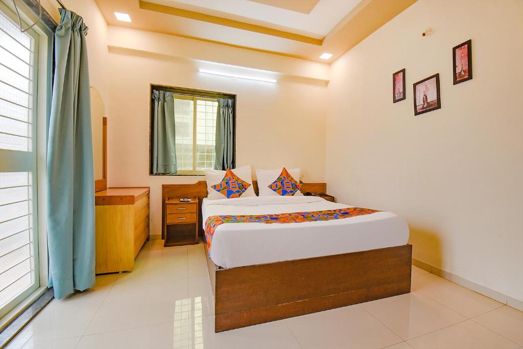 Un dormitorio con una cama grande y una ventana en FabHotel Galaxy Inn, en Pune